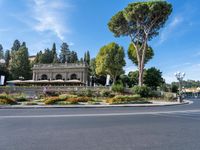 a beautiful place to live with people sitting and walking next to the road at the curb