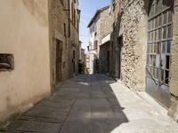 small cobbled in street with stone houses and stone walls on both sides of buildings