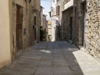 small cobbled in street with stone houses and stone walls on both sides of buildings