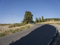 a person on a motorcycle riding on a road in front of a hill with trees