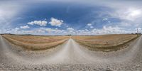 the sky is reflected on a panorama of a road in a wheat field with an arrow pointing to it