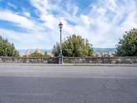 a street light sitting in the middle of a road with a small bridge between it