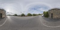 two buildings and a road in front of the sky, seen through fisheye lens