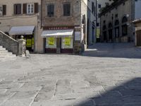 a sidewalk near an old building with a street sign on it that says luberini