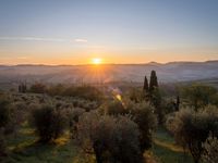 the sun shines brightly in this beautiful, tuscan - like landscape, but the light reflects it's orange color