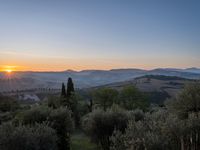 the sun shines brightly in this beautiful, tuscan - like landscape, but the light reflects it's orange color