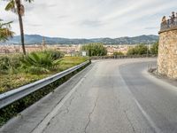 an old winding highway is leading to a large town with palm trees in the distance