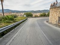 an old winding highway is leading to a large town with palm trees in the distance