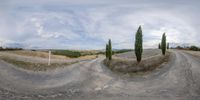 three different images of an empty dirt road and street signs in various directions with fields in the background