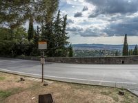 a street with an arrow and the corner by the road, near a large mountain