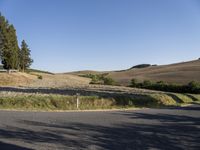 a street view shows the landscape and hills below on the road that leads to town