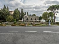 a building that is next to a road and some trees and a statue near it