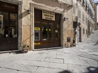 a building in a narrow alley has a door to the shopfront on it's side