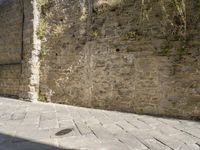 a stone wall is in the middle of a street, which has small holes in it