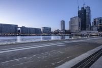 there are many buildings by the water in this city at twilight times and the water is frozen over