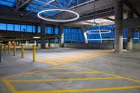 a view of an open parking lot at twilight with yellow lines on the ground, a streetlight and some pillars