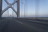 the car is driving on the bridge at twilighttime in motion around the edge of the bridge