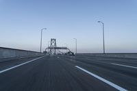 there are many vehicles driving on the highway under the bridge together at twilight time,