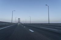 there are many vehicles driving on the highway under the bridge together at twilight time,