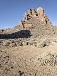 two men on skis in front of some rocky outcropping in the desert