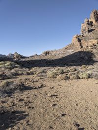 two men on skis in front of some rocky outcropping in the desert