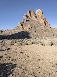 two men on skis in front of some rocky outcropping in the desert