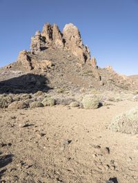 two men on skis in front of some rocky outcropping in the desert