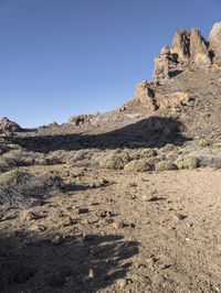 two men on skis in front of some rocky outcropping in the desert