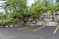 two parking spaces with yellow line markings next to rock wall in a residential neighborhood area