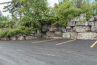 two parking spaces with yellow line markings next to rock wall in a residential neighborhood area