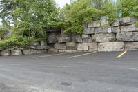 two parking spaces with yellow line markings next to rock wall in a residential neighborhood area