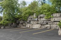 two parking spaces with yellow line markings next to rock wall in a residential neighborhood area