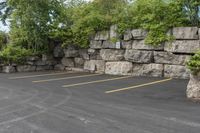 two parking spaces with yellow line markings next to rock wall in a residential neighborhood area