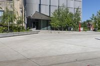 two people holding skateboards standing in an open courtyard space near buildings and a statue