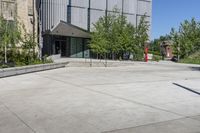 two people holding skateboards standing in an open courtyard space near buildings and a statue