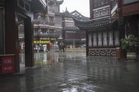 two people walking in the rain on a city street near a building with two towers