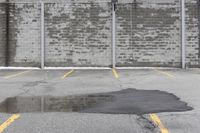 the empty parking lot has only snow on the ground in front of an old brick factory