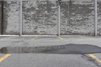 the empty parking lot has only snow on the ground in front of an old brick factory