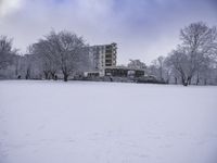 two snow skiers and an apartment in the background as they are out in their winter gear