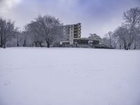 two snow skiers and an apartment in the background as they are out in their winter gear