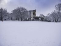 two snow skiers and an apartment in the background as they are out in their winter gear