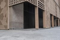 a couple of people sitting on benches next to a building on a city street during the day