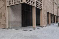 a couple of people sitting on benches next to a building on a city street during the day
