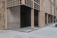 a couple of people sitting on benches next to a building on a city street during the day