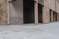 a couple of people sitting on benches next to a building on a city street during the day