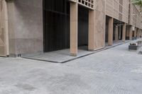 a couple of people sitting on benches next to a building on a city street during the day