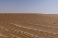 there is a small boat in the sand of this desert area with no trees or bushes