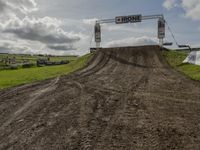 dirt track with signage for a bike club in a field during the day light hours