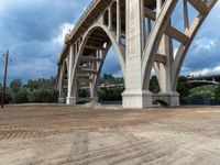 a view from under a highway overpass on a cloudy day with blue skies and grey clouds