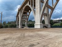 a view from under a highway overpass on a cloudy day with blue skies and grey clouds